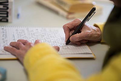 Closeup of Gayen writing. Pen on paper in notebook.